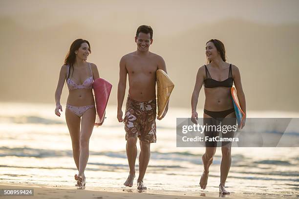 friends walking out of the water after surfing - hanalei national wildlife refuge stock pictures, royalty-free photos & images