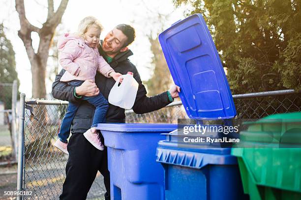 vater und kind mit recycling papierkorb heraus - milchkrug stock-fotos und bilder