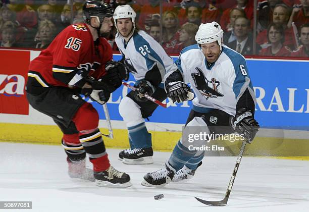 Defenseman Jason Marshall of the San Jose Sharks is pressured by left wing Chris Simon of the Calgary Flames during game three of the 2004 NHL...