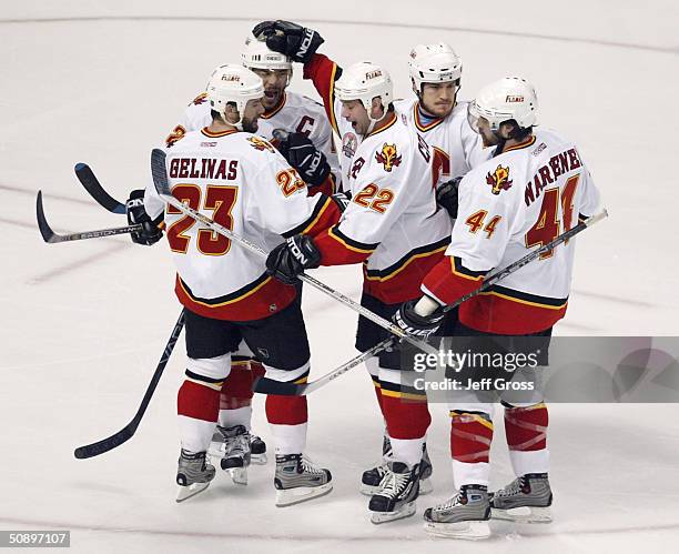 Craig Conroy and Jarome Iginla of the Calgary Flames celebrate with teammate Martin Gelinas after Gelinas scored the team's first goal against the...