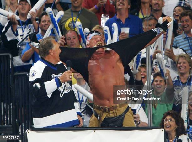 Hockey Hall of Famer Phil Esposito watches as professional wrestler Hulk Hogan rips his shirt off following the singing of the National Anthem by his...