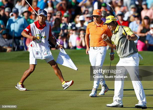 Hideki Matsuyama of Japan celebrates a birdie putt on the 18th hole as Rickie Fowler looks on during the final round of the Waste Management Phoenix...
