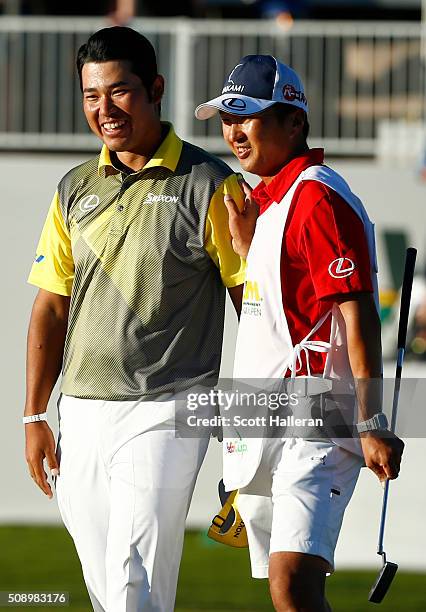 Hideki Matsuyama of Japan celebrates with his caddie Daisuke Shindo after putting in to win on the fourth playoff hole on the 17th hole during the...