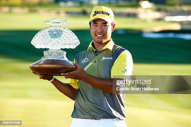Hideki Matsuyama of Japan poses with the winners trophy on the 18th hole during the final round of the Waste Management Phoenix Open at TPC...