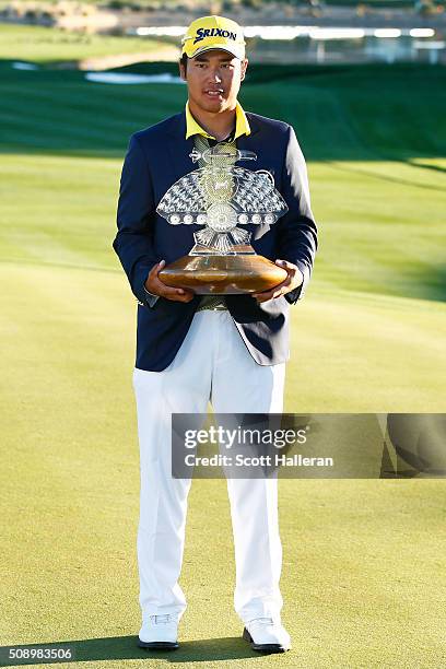 Hideki Matsuyama of Japan poses with the winners trophy on the 18th hole during the final round of the Waste Management Phoenix Open at TPC...