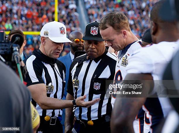 Referee Clete Blakeman looks at the coin with Peyton Manning of the Denver Broncos prior to playing the Carolina Panthers in Super Bowl 50 at Levi's...