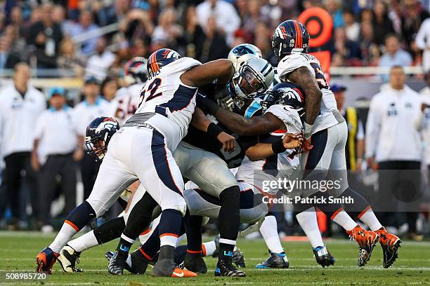 Cam Newton of the Carolina Panthers is tackled by Sylvester Williams and Malik Jackson of the Denver Broncos in the first half during Super Bowl 50...