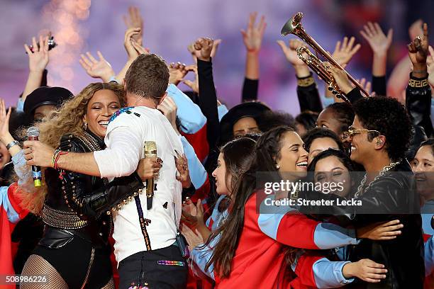 Beyonce hugs Chris Martin of Coldplay while Bruno Mars hugs fans following the Pepsi Super Bowl 50 Halftime Show at Levi's Stadium on February 7,...