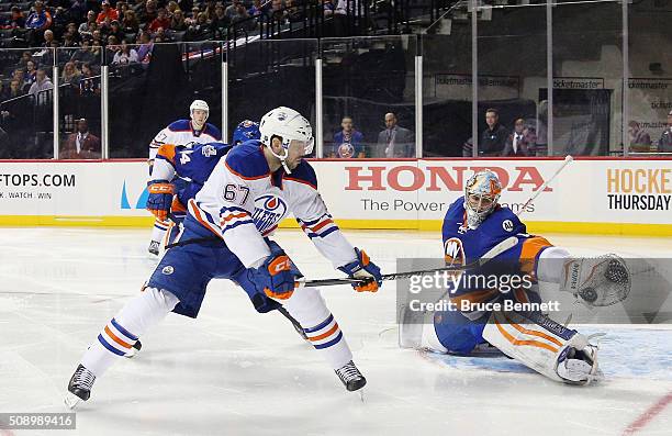 Thomas Greiss of the New York Islanders stops a shot by Benoit Pouliot of the Edmonton Oilers at the Barclays Center on February 7, 2016 in the...