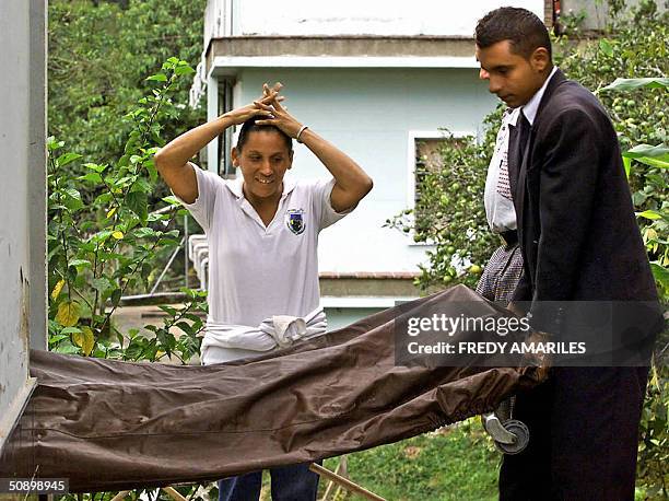 La senora Maria Esperanza Romero Posada observa la salida de la morgue de Corcona del cadaver de un familiar el 25 de mayo de 2004. Cinco personas...