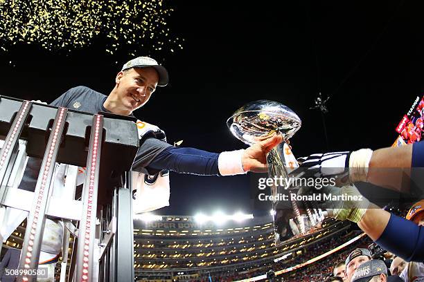 Peyton Manning of the Denver Broncos is handed the Vince Lombardi Trophy after defeating the Carolina Panthers during Super Bowl 50 at Levi's Stadium...