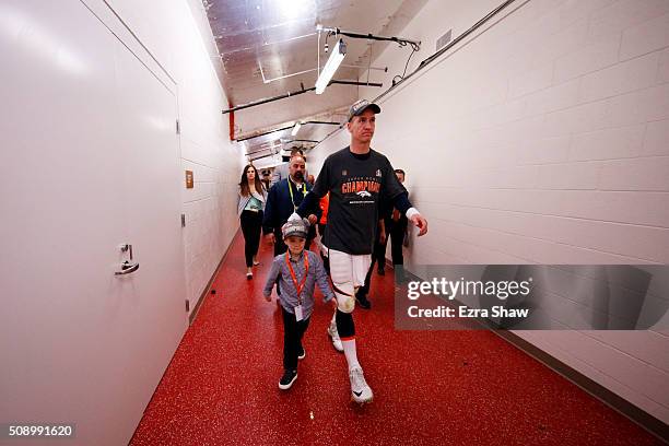 Peyton Manning of the Denver Broncos walks with his son Marshall Manning after defeating the Carolina Panthers during Super Bowl 50 at Levi's Stadium...