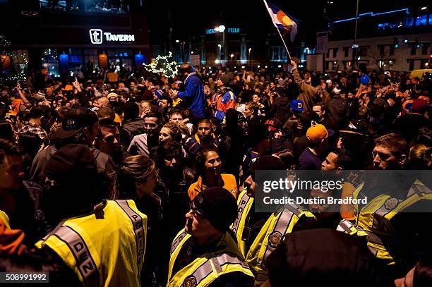 Denver Broncos fans celebrate in the street as Denver police officers walk through the crowd after the Denver Broncos won Super Bowl 50 on Market...