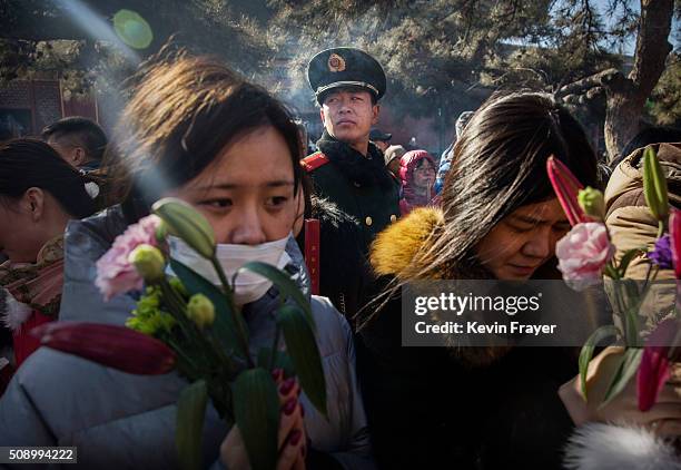 Paramilitary police officer watches over Chinese worshippers as they pray at the Yongchegong Lama Temple on February 8, 2016 in Beijing, China. The...