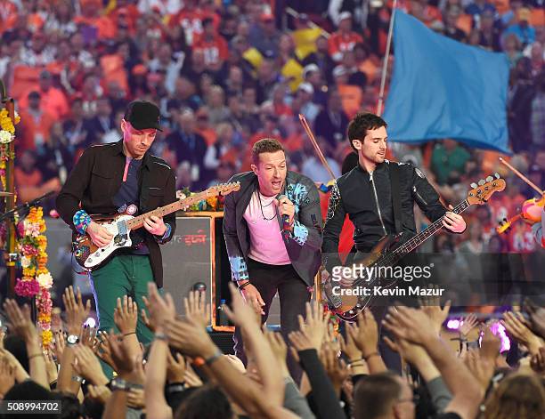 Jonny Buckland, Chris Maritn and Guy Berryman of Coldplay perform onstage during the Pepsi Super Bowl 50 Halftime Show at Levi's Stadium on February...