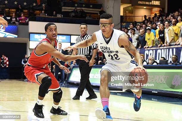 Joe McDonald of the George Washington Colonials dribbles around ShawnDre' Jones of the Richmond Spiders during a college basketball game at the Smith...