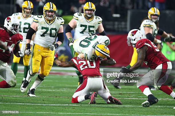 Deone Bucannon of the Arizona Cardinals tackles John Kuhn during the game against the Green Bay Packers at University of Phoenix Stadium on January...