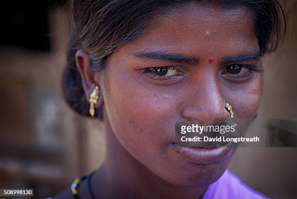 An Indian woman from a poor rural village looks on.