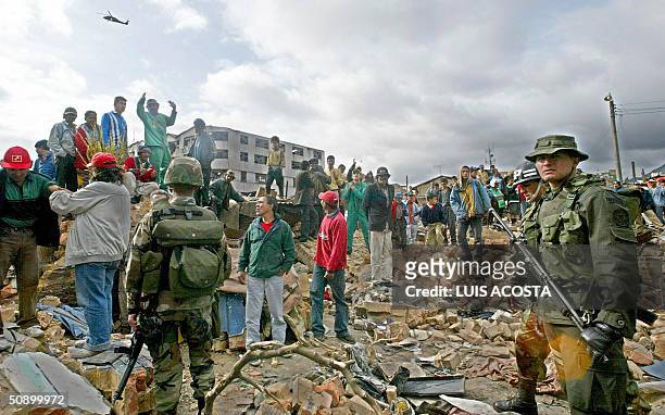 Foto tomada el 07 de agosto de 2002 en Bogota de soldados y miembros de grupos de rescate en el lugar donde exploto una bomba durante la investidura...