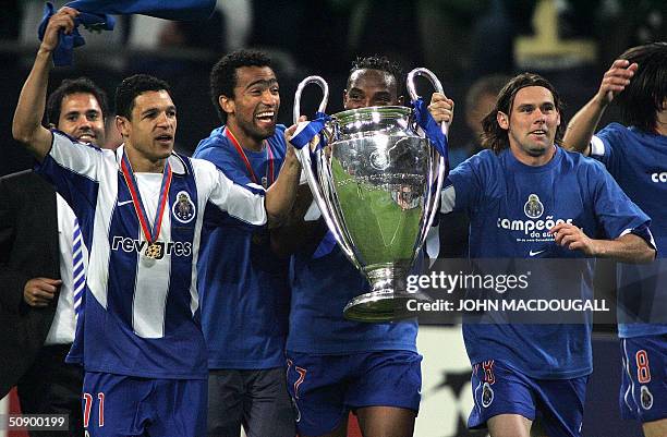 Porto's Derlei, Jose Bosingwa, Benni McCarthy and Maniche run with the trophy after beating Monaco 3-0 in the final of the Champions league football...