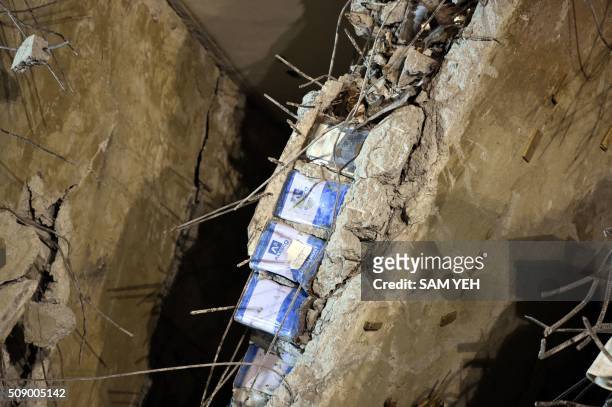 Blue paint cans, seen sandwiched in between a layer of concrete, is seen at the Wei-Kuan complex which collapsed in the 6.4 magnitude earthquake, in...