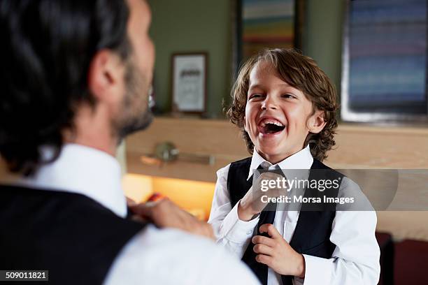 boy adjusting tie while looking at father - stylish dad stock pictures, royalty-free photos & images