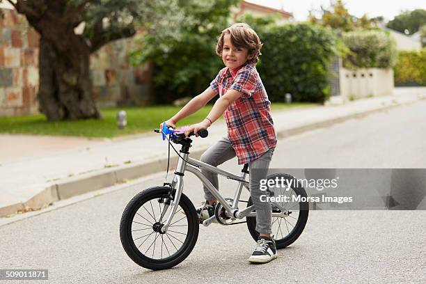 confident boy sitting on bicycle - kids on bikes stockfoto's en -beelden