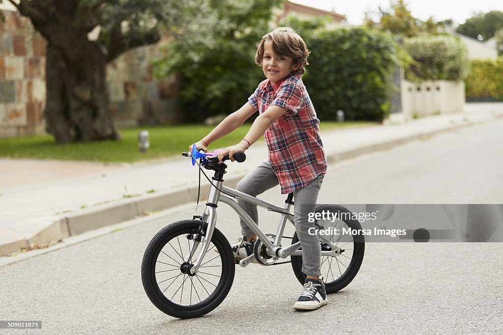 Confident boy sitting on bicycle