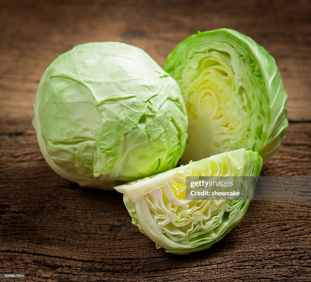 Cabbage and cutted cabbage on wooden