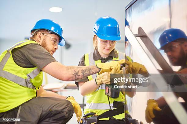 female construction apprentice and colleague - school building stockfoto's en -beelden