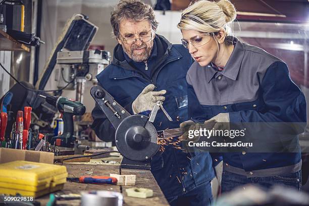 young woman grinding metal in mechanical workshop - metal workshop stockfoto's en -beelden