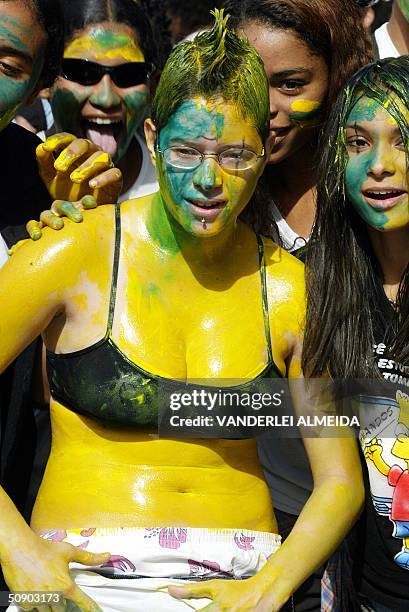 Jovenes estudiantes de secundaria con el cuerpo pintado con colores de la bandera de Brasil, gritan durante una manifestacion en una plaza centrica...