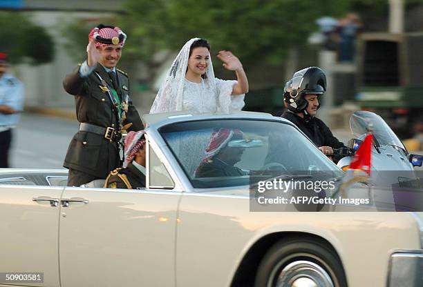 Jordanian Crown Prince Hamza and his bride Princess Noor wave to wellwishers as they ride in a 1961 Lincoln Continental, that has been traditionally...