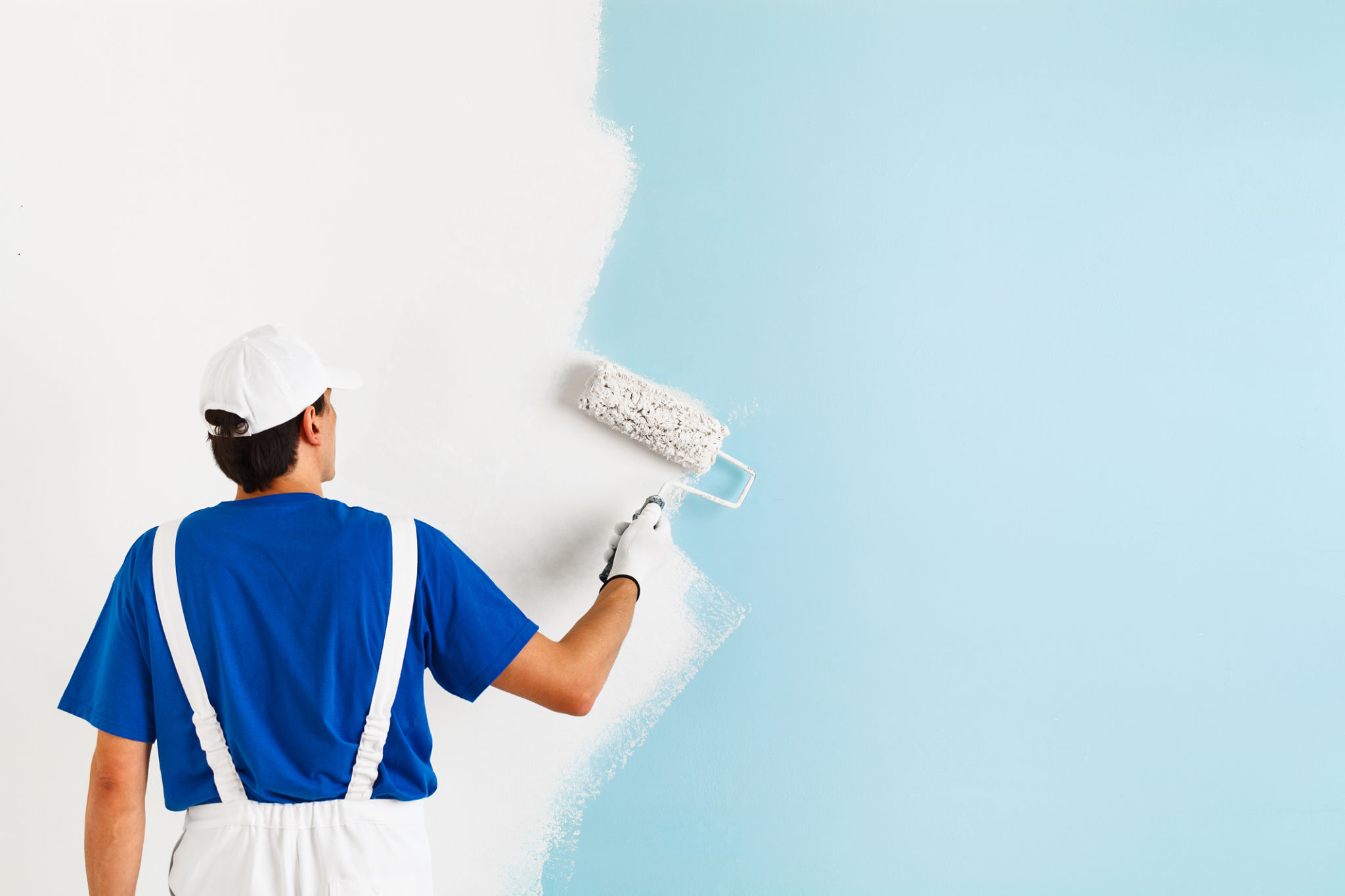 painter painting a wall with paint roller painter painting a wall with paint roller