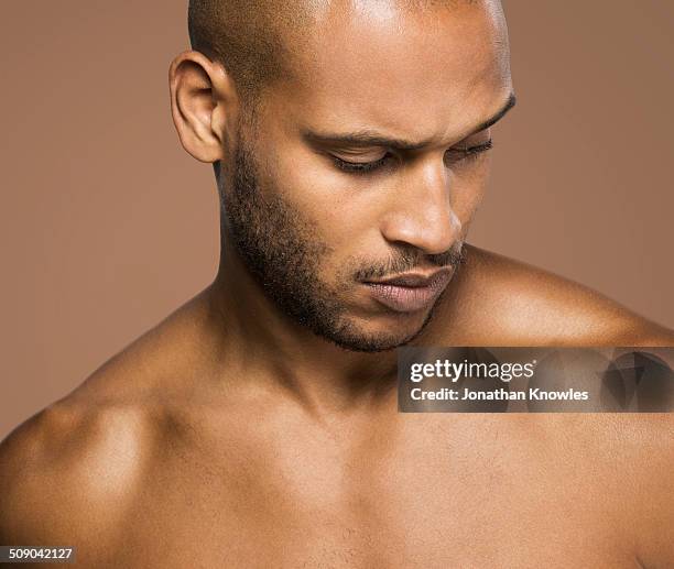 dark skinned athletic male, looking down - torso stock-fotos und bilder