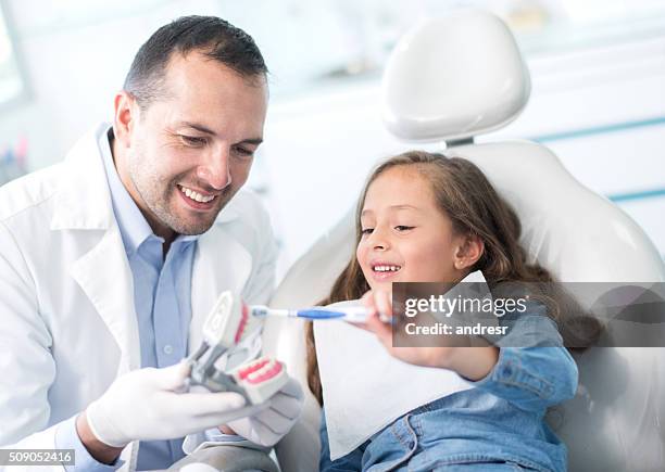 girl at the dentist learning how to brush her teeth - pediatric dentistry stock pictures, royalty-free photos & images