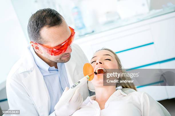 dentista usando laser para corrigir uma cavidade - abscess - fotografias e filmes do acervo