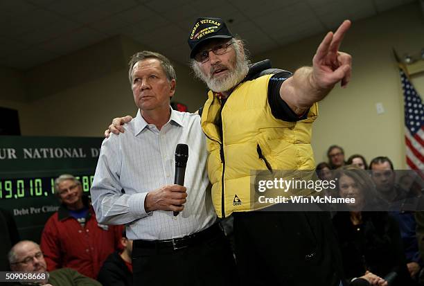 Vietnam veteran David AuCoin puts his arm around Republican presidential candidate, Ohio Gov. John Kasich , as he asks the candidate a question...