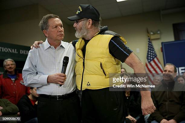 Vietnam veteran David AuCoin puts his arm around Republican presidential candidate, Ohio Gov. John Kasich , as he asks the candidate a question...