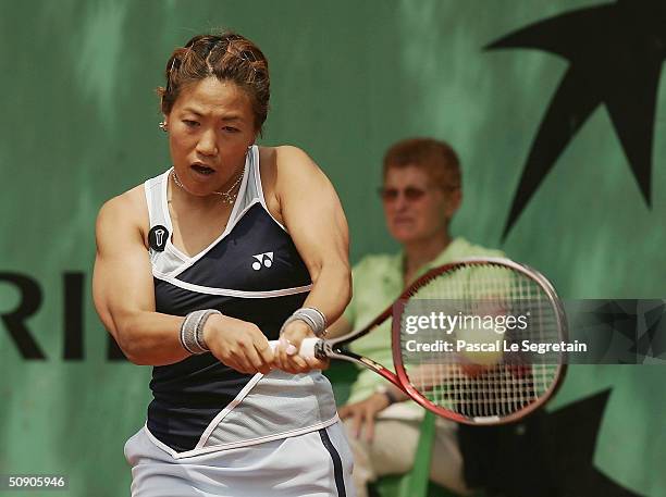 Rika Fujiwara of Japan plays a return during her second round doubles match with Shinobu Asagoe of Japan during Day Five of the 2004 French Open...