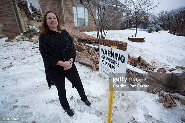 December 29: Dawne Sullivan, stands besides her home's fireplace, December 29, 2015 in Edmond, Oklahoma. Her home was damaged by an earthquake. Many...