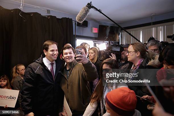Republican presidential candidate Sen. Marco Rubio poses for photographs with people at the Village Trestle restaurant during a campaign stop...