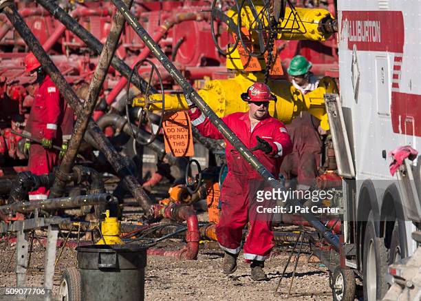 Haliburton oil field worker prepares a pipe to be installed on a fracking rig January 27, 2016 near Stillwater, Oklahoma.