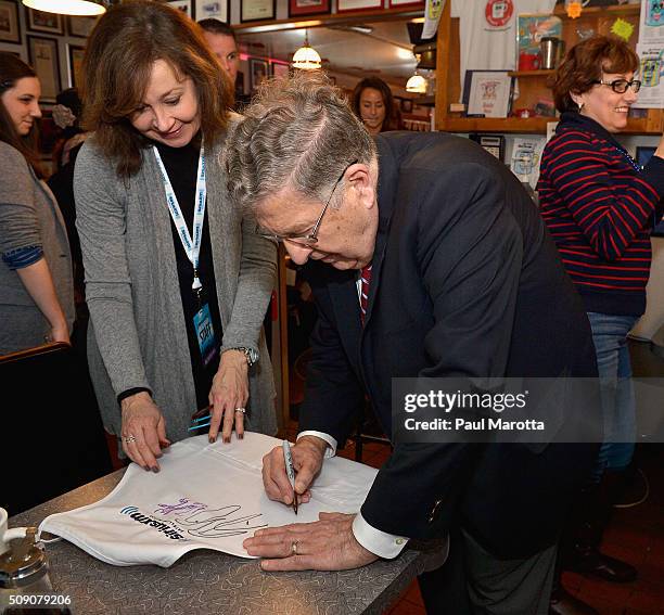 Former New Hampshire Governor John Sununu autographs a SiriusXM cooking apron at SiriusXM Broadcasts' New Hampshire Primary Coverage Live From Iconic...