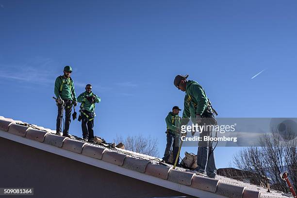 Worker takes measurements on the roof during a SolarCity Corp. Residential installation in Albuquerque, New Mexico, U.S., on Monday, Feb. 8, 2016....