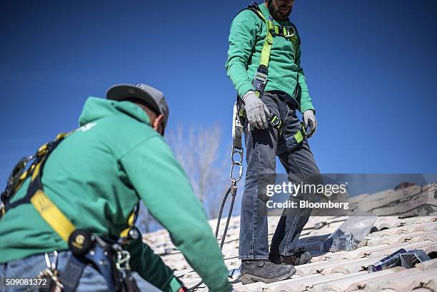 Workers stand on a rooftop during a SolarCity Corp. Residential installation in Albuquerque, New Mexico, U.S., on Monday, Feb. 8, 2016. SolarCity is...