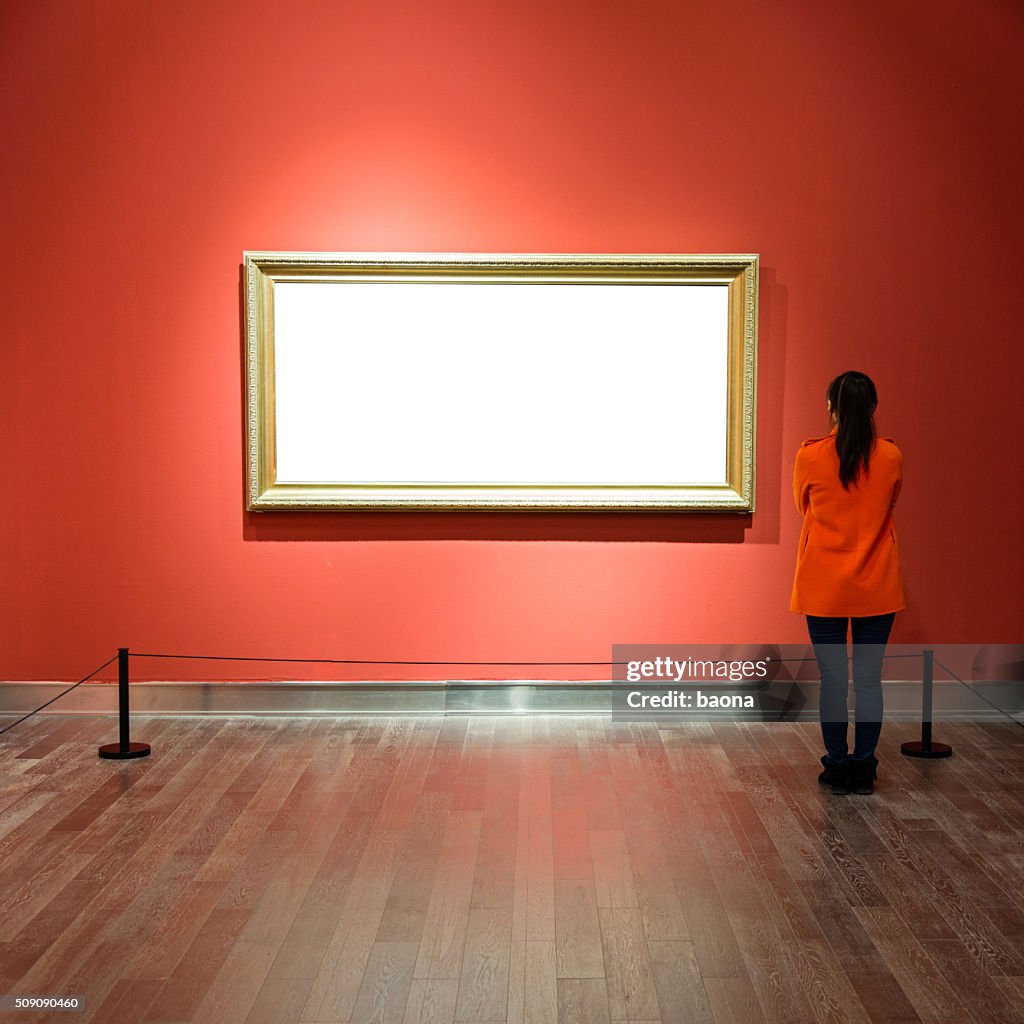 Young woman looking at artwork
