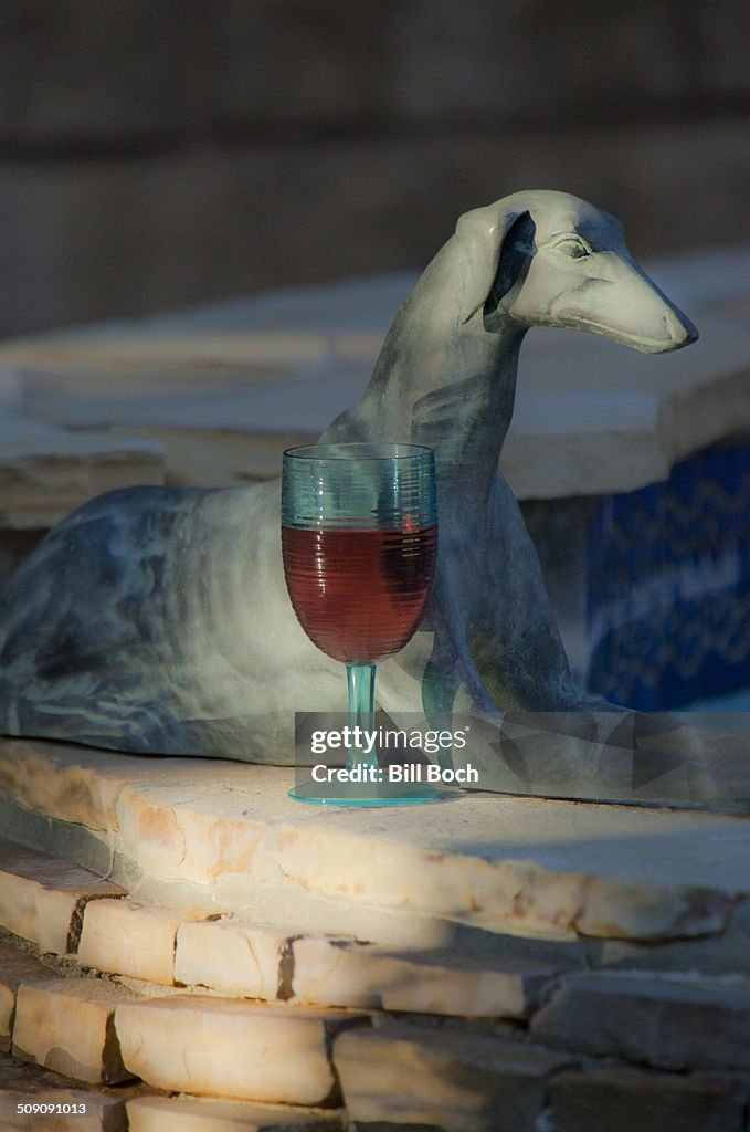 Red wine glass by antique dog figure