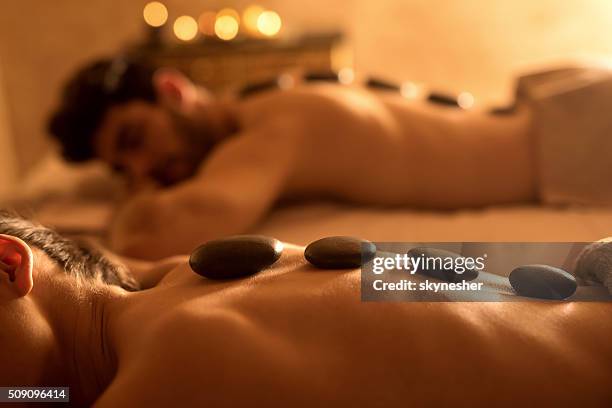 irreconocible mujer que reciben terapia de piedras calientes en el spa. - terapia lastone fotografías e imágenes de stock