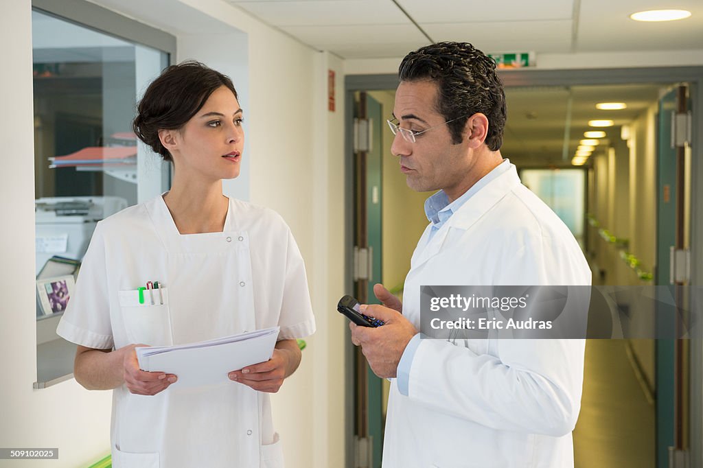 Doctor and nurse discussing in hospital corridor